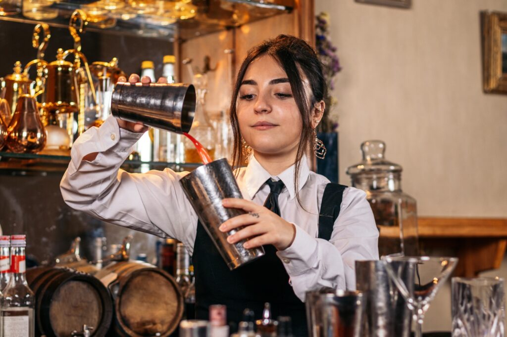 Female bartender preparing a cocktail in a traditional cocktail bar