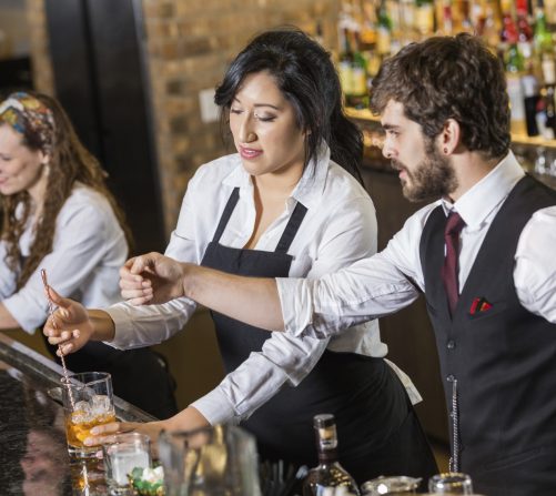 Bartender training at 786-Bartend in Miami, learning cocktail techniques and bar skills from an instructor.